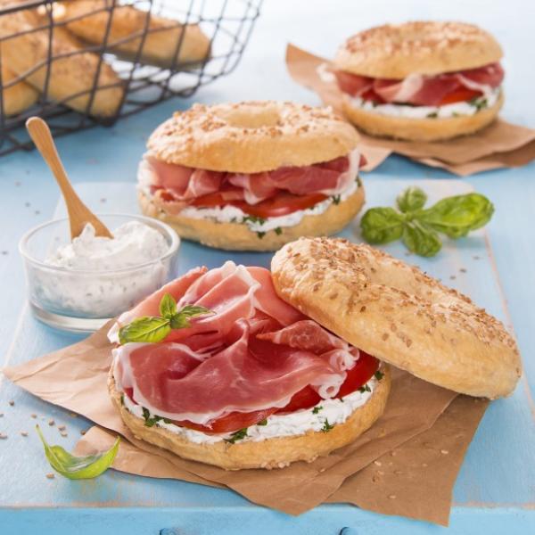 Three pieces of coated bread with grass, tomatoes and Parma ham.