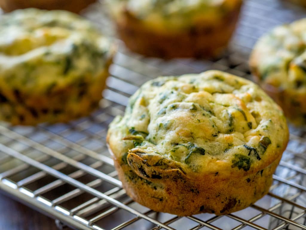 Muffins with spinach placed on a griddle.