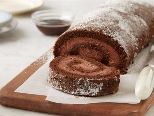 Sliced cocoa roll with Parisian whipped cream sprinkled with powdered sugar