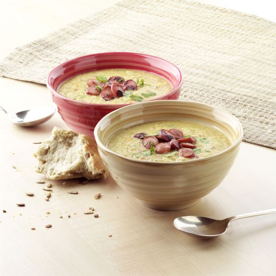 Cremige Suppe mit Wurst, Kartoffeln und frischem Liebstöckel.