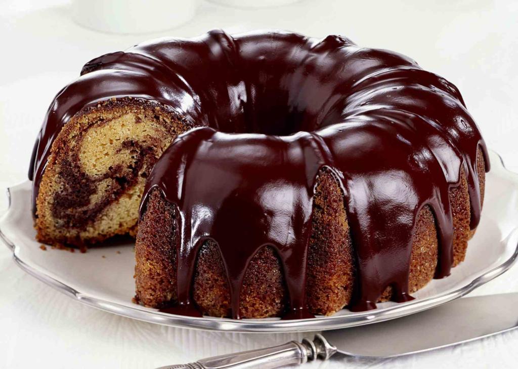 Marble cake topped with chocolate glaze on a plate.