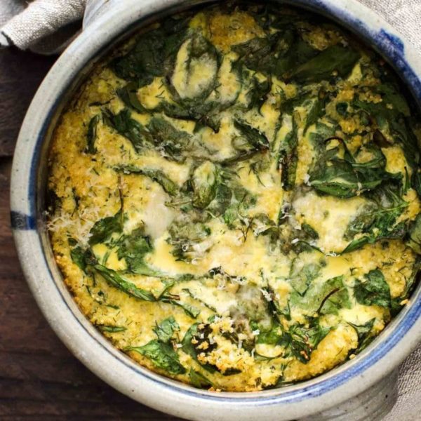 Millet-cheese pudding with spinach in a baking dish.
