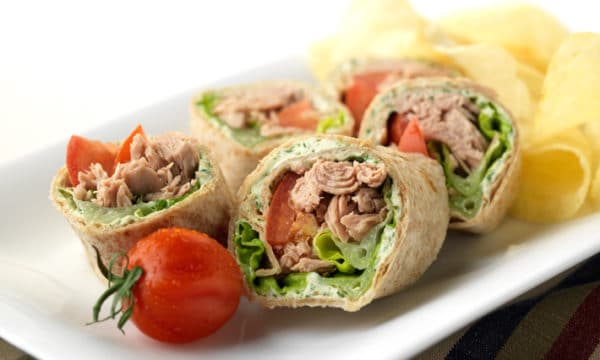 Sliced ​​tortilla canapés with tuna, served with tomato and cheese.