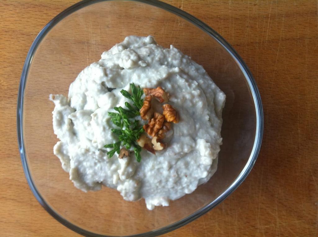 Cottage cheese spread from the plain in a glass bowl, decorated with walnuts
