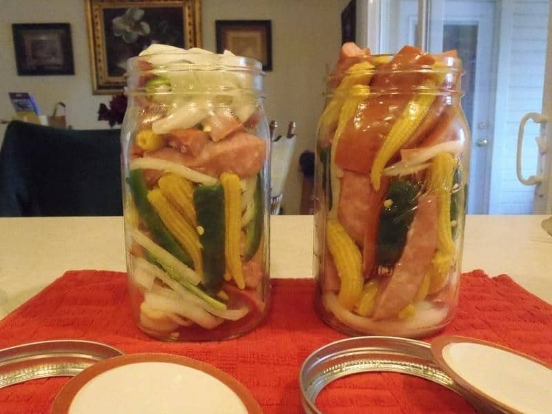 Klobásy naložené ve sklenicích se zeleninou.