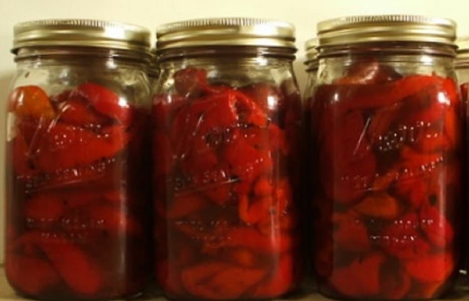 Zavařované červené papriky ve sklenicích.