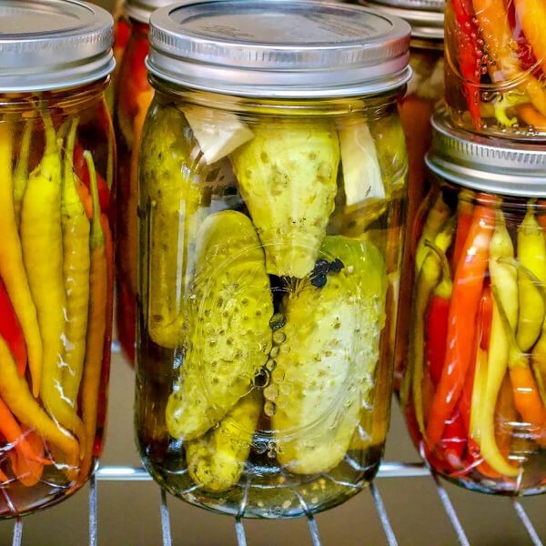 Nakládané okurky a papričky v zavařovacích sklenicích.