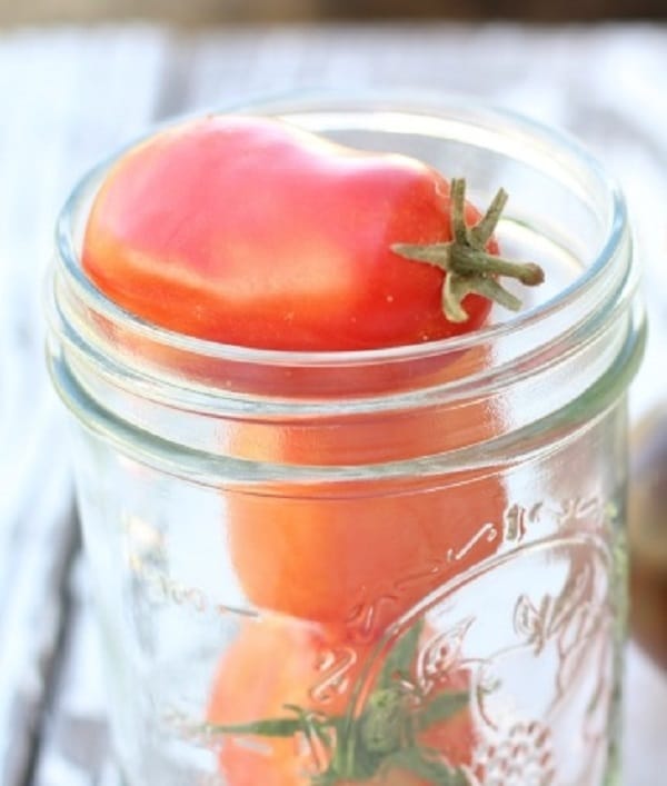 Celá rajčata ve sklenici.