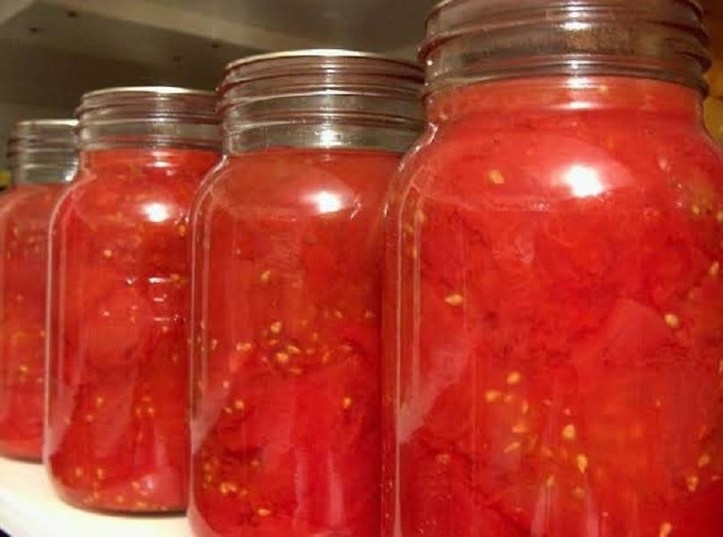 Nakládaná rajčata v zavařovacích sklenicích.