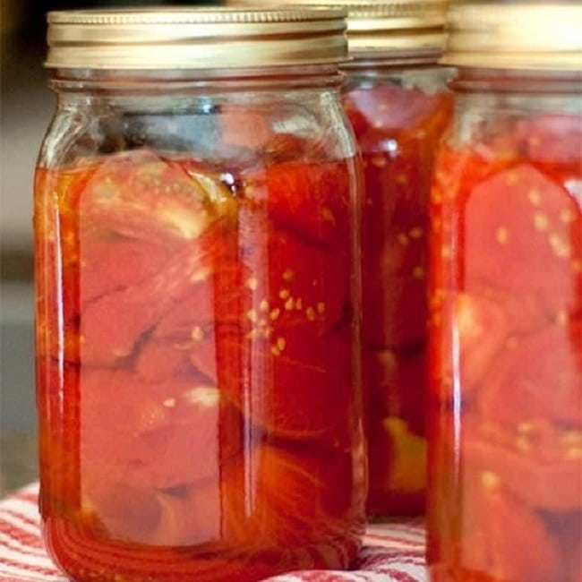 Pickled tomatoes in canning jars.