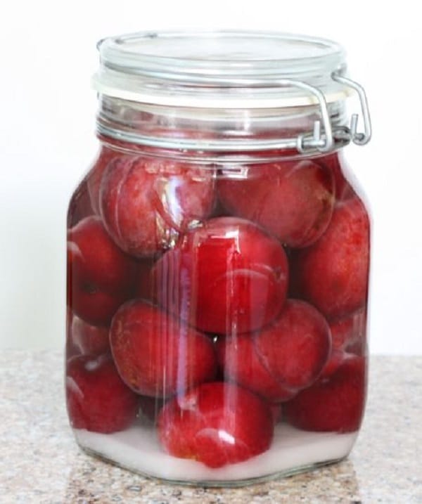 Pickled plums in a jar.