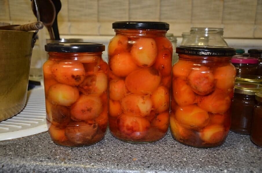 Pickled plums in jars.