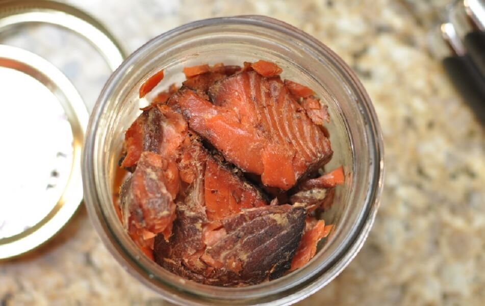 Uzené rybí maso naložené v zavařovací sklenici.