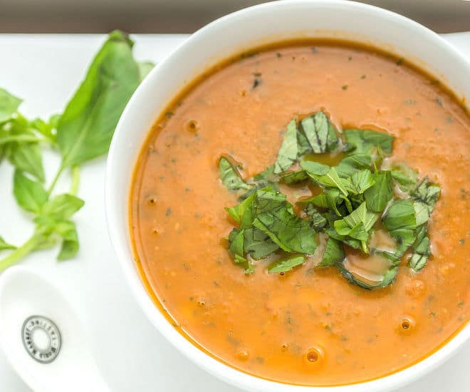 Creamy chickpea soup in a deep dish, garnished with fresh herbs.