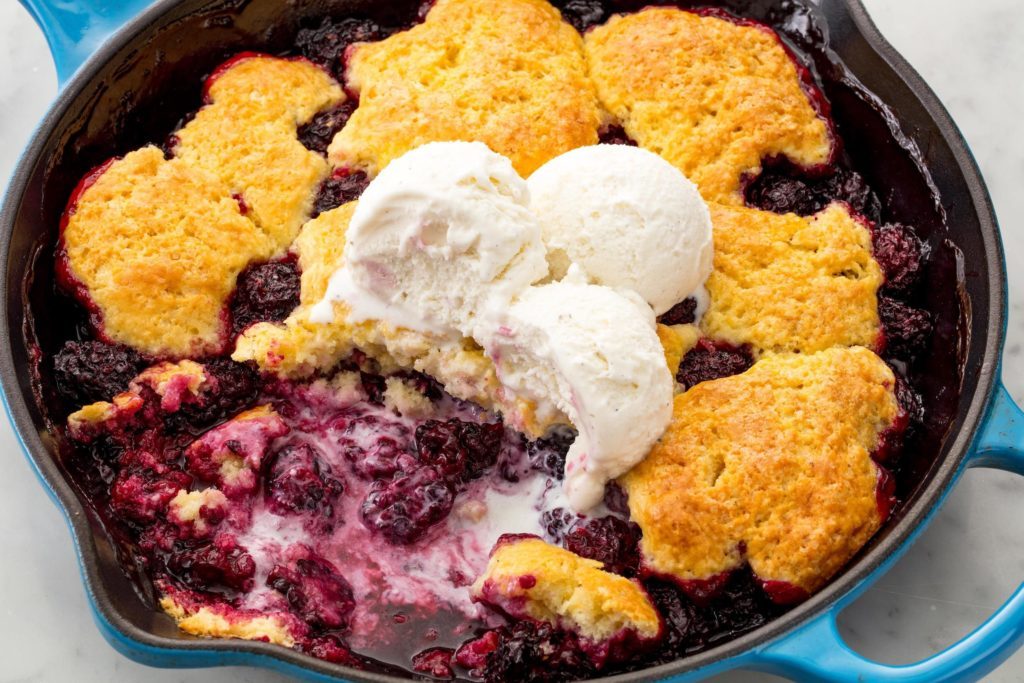 baked pie with blueberries and custard filling, decorated with scoops of ice cream