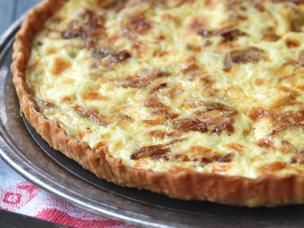round baked pie with onions and cheese