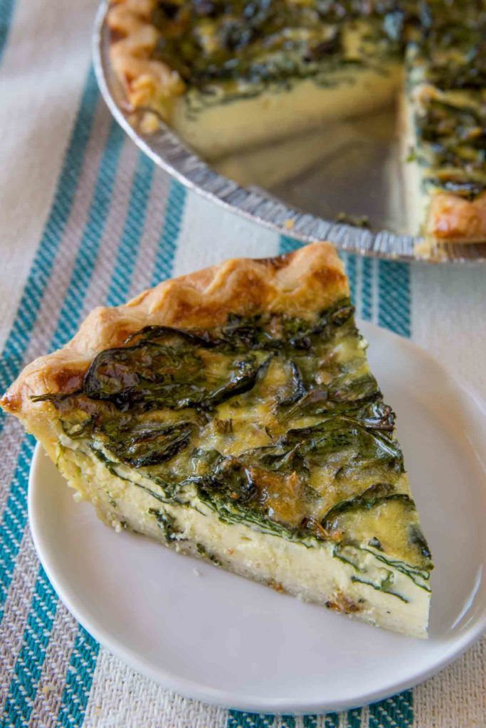 baked pie with spinach filling and plated spinach