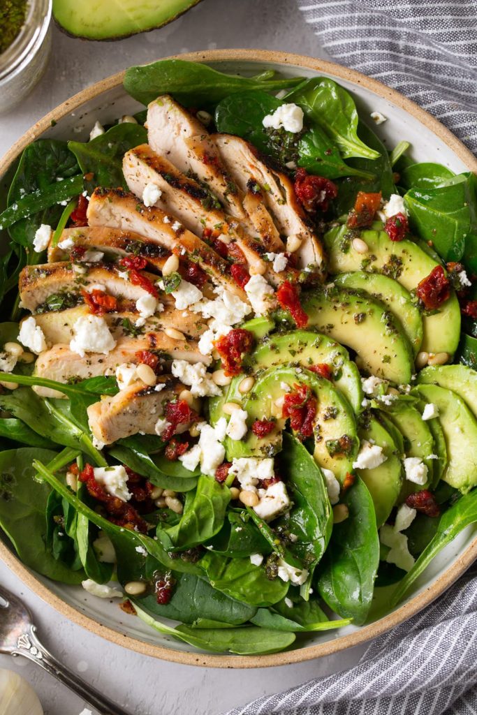 Chicken salad with spinach and tomatoes as a hearty dinner.