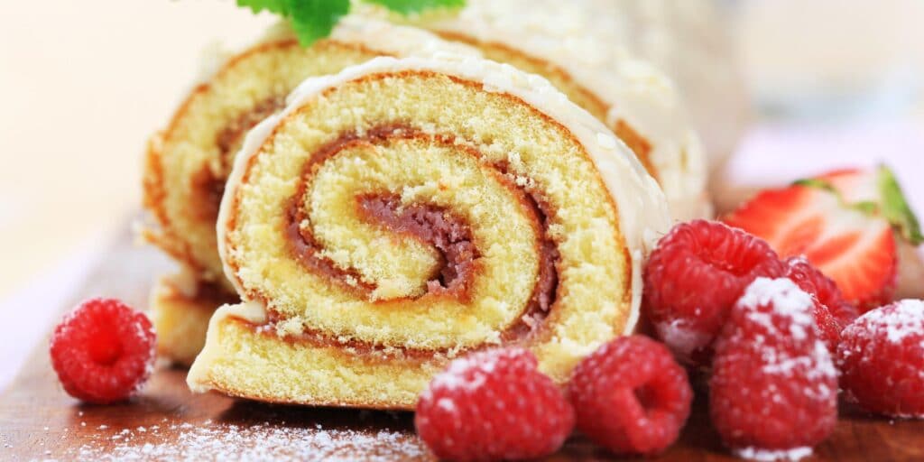 Roll made of sponge dough with a mint leaf and fruit