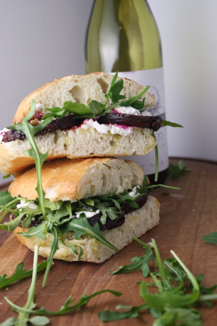Two buns filled with goat cheese, arugula and slices of beetroot