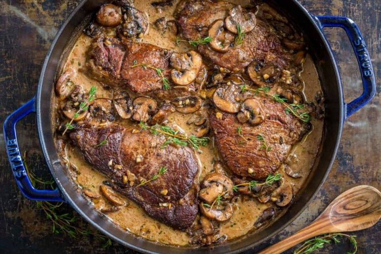 Beef leg on mushrooms and red wine with herbs
