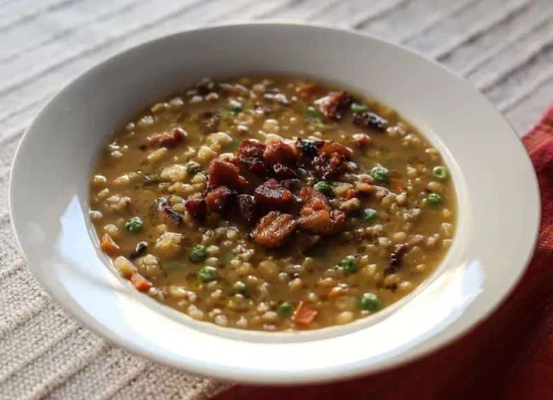 Pea, lentil and groats soup served with fried bacon