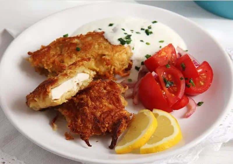 Chicken cutlets in potato batter served with tartar sauce and vegetable garnish
