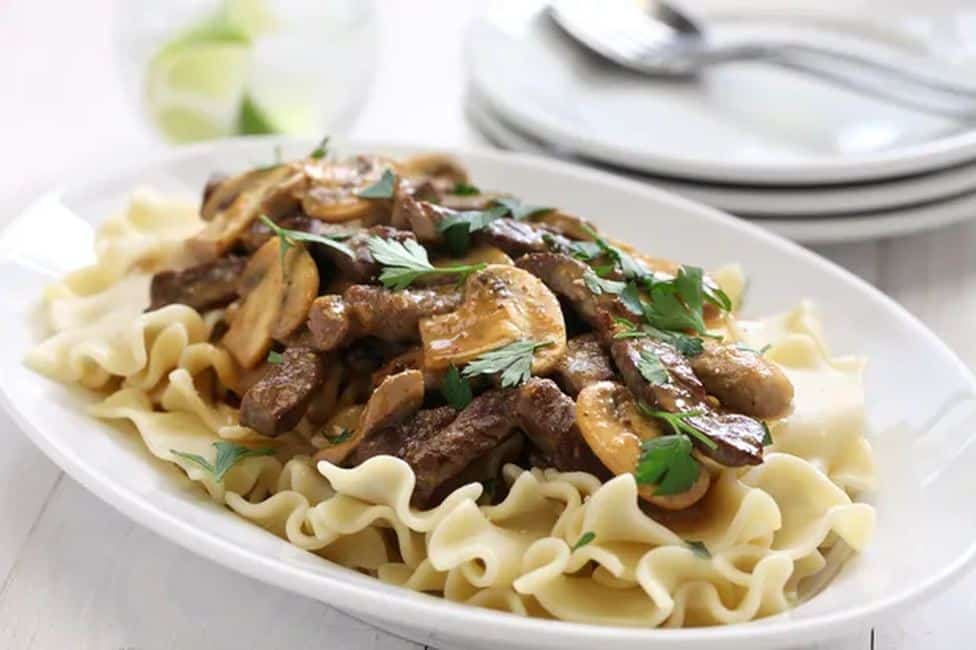 A mixture of beef and mushroom noodles served on pasta