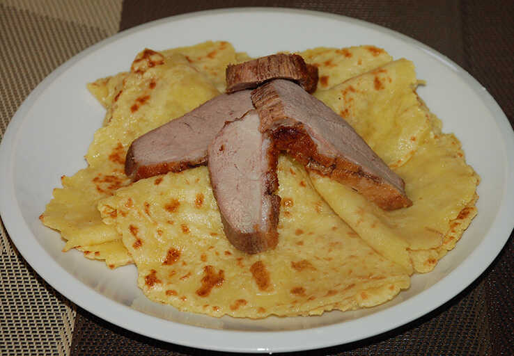 Gluten-free potato pancakes with duck breast on a plate
