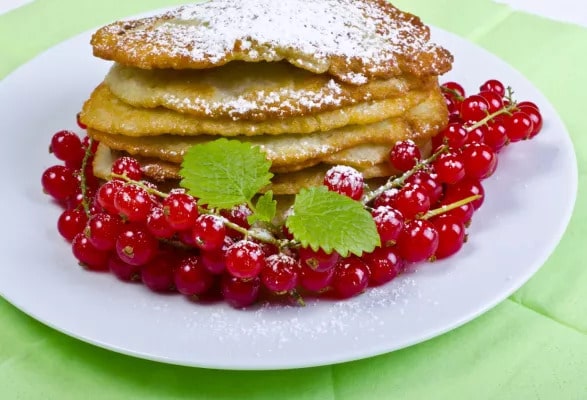 Potato pancakes with red currant on a plate