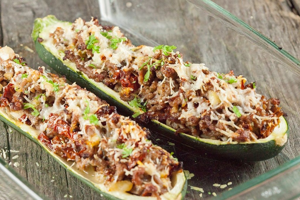 Two zucchini boats filled with meat and sprinkled with cheese