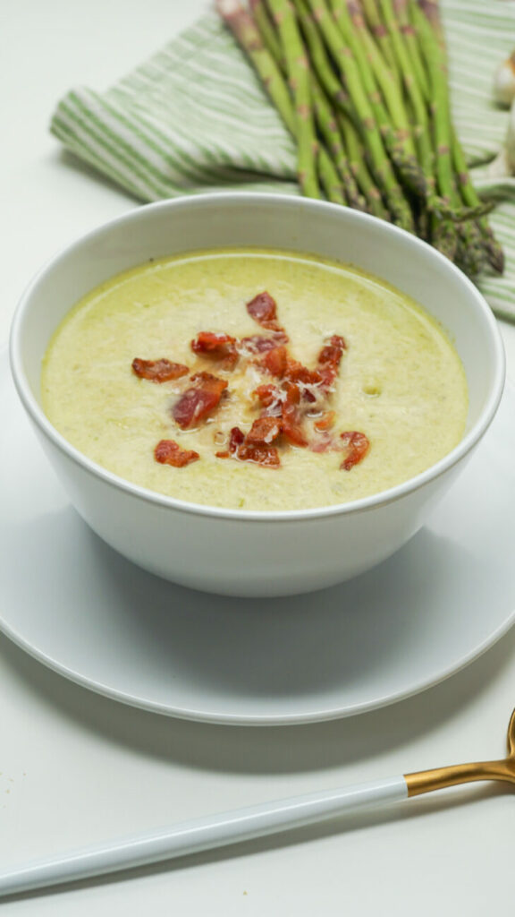 Asparagus soup decorated with pieces of fried bacon
