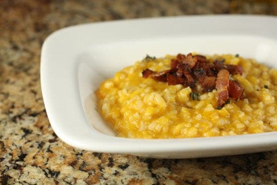 Creamy pumpkin rice with toasted bacon in a white square plate