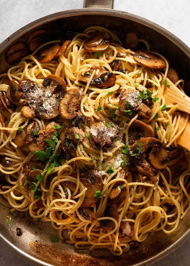 Penne with mushrooms, parmesan and parsley in a pan.