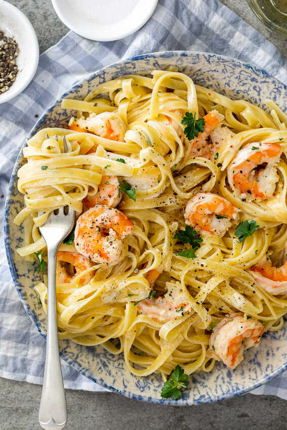 Tagliatelle with shrimps on a plate with a fork.