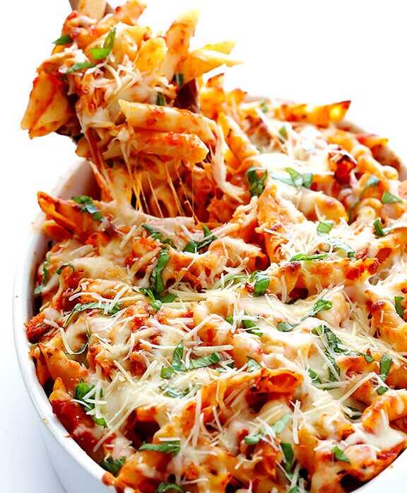 Baked penne with cheese and basil in a bowl.