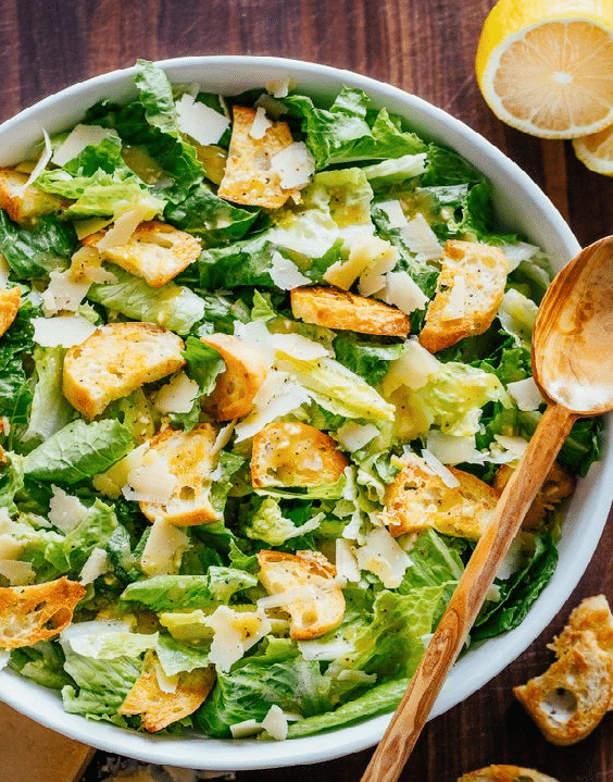 Leaf salad with dressing, chicken and croutons.