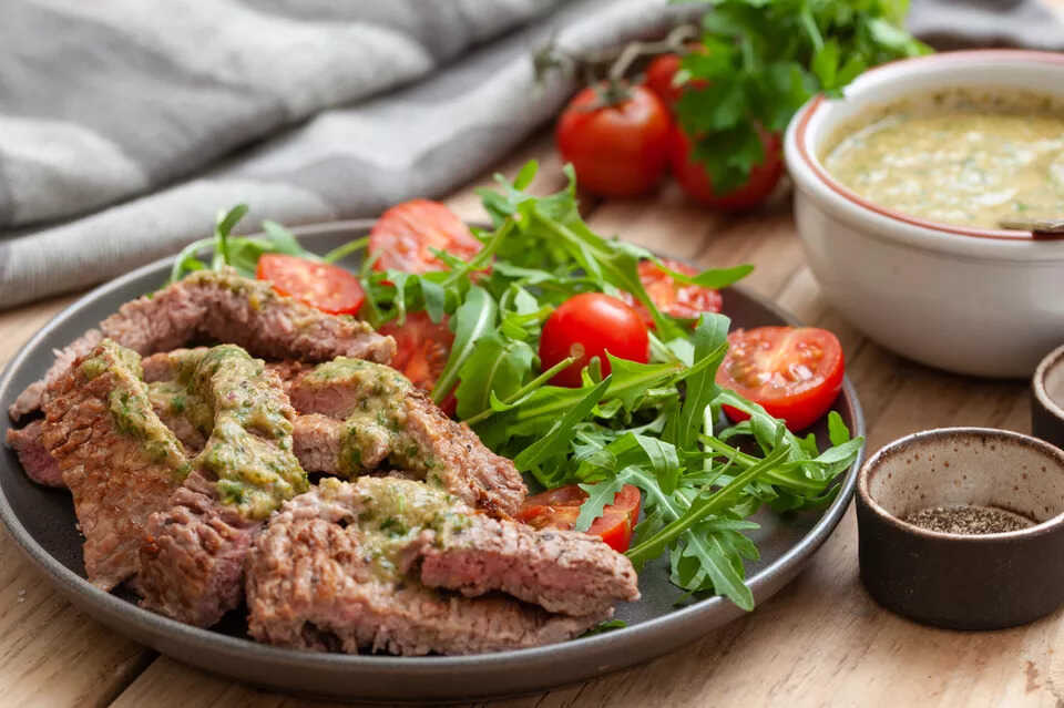 Hovězí steak s remuládou a zeleninovým salátem na talíři.