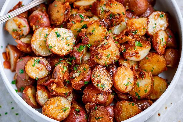 Baked potatoes with bacon and parsley in a bowl.