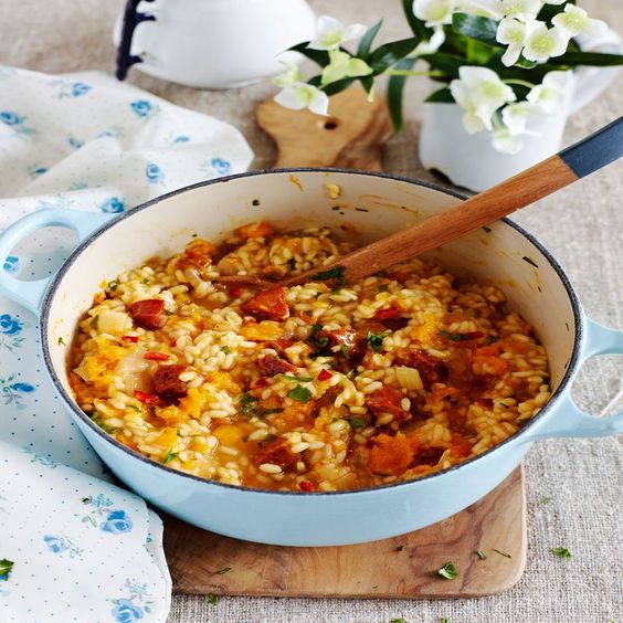 A bowl of spicy risotto sprinkled with herbs.