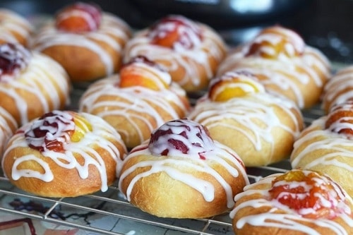 Cakes with plums in the middle, topped with white icing.