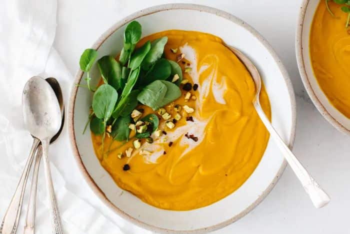Soft sweet potato cream served with herbs and i and pistachios