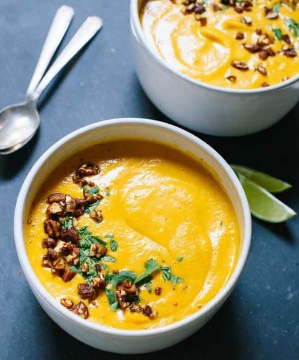 Sweet potato, carrot and ginger cream decorated with herbs and roasted nuts