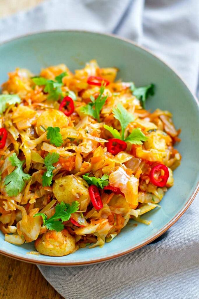 White cabbage with potatoes, chili and coriander on a plate.