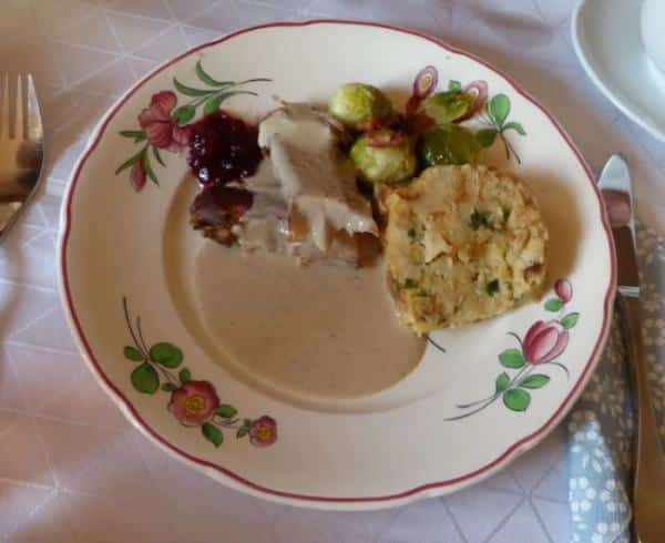 Wild boar leg dish in cream sauce served with dumpling, Brussels sprouts and cranberries