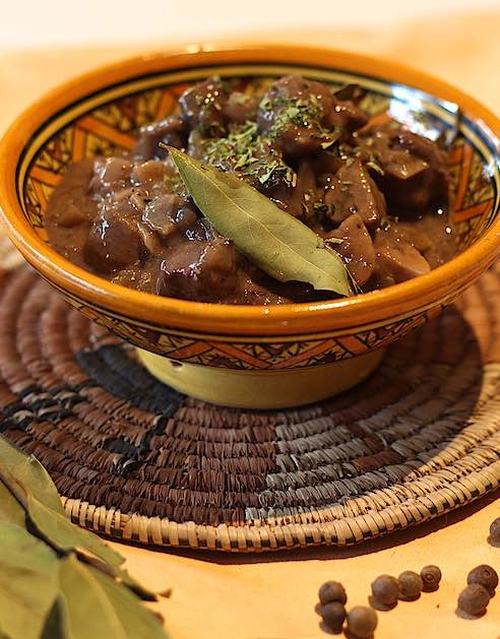 A bowl with a mixture of boar meat, mushrooms and sauce