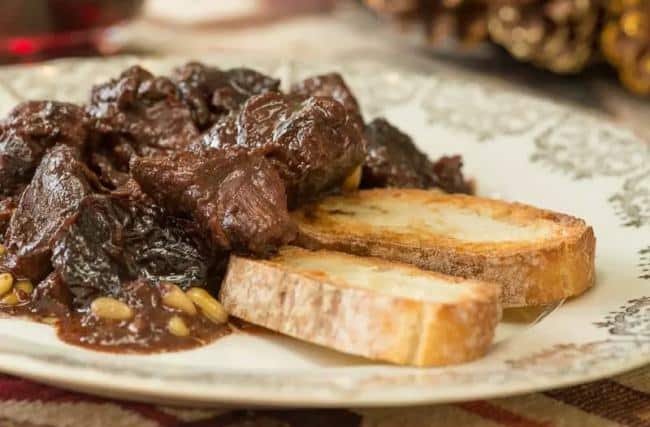 Pieces of wild boar leg served with pine nuts and slices of toasted bread