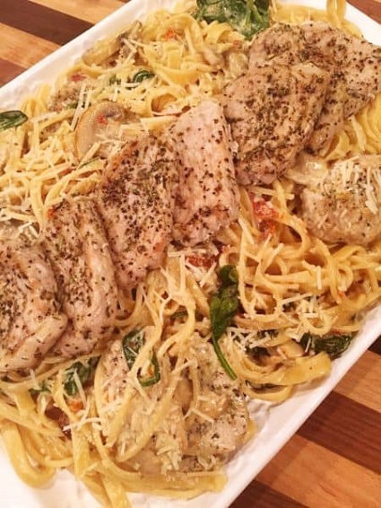 Spaghetti with pork tenderloin and cheese sauce, served with fresh herbs.
