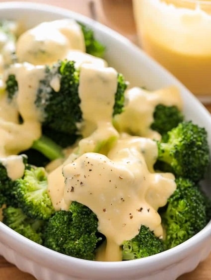 Cooked broccoli topped with nutmeg cheese sauce.