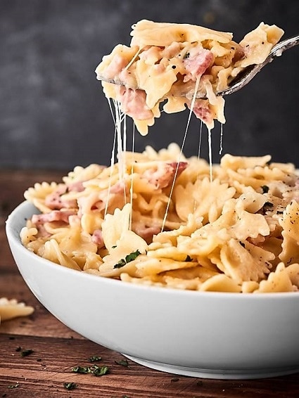 Butterfly pasta with ham and cheese sauce.